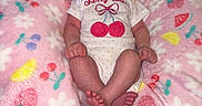 Everleigh is registered to the contest to win money with this photo: baby, infant, onesie, pink_blanket, fruit_pattern, floral_pattern, cute, relaxed, indoor, person, newborn, soft_texture, footwear_bare, lying_down, child, sleepwear, decorative_blanket, small_hands, small_feet, expression
