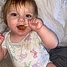Kody is registered to the contest to win money with this photo: baby, child, lollipop, smiling, sitting, blanket, bed, onesie, happy, cute, indoors, face, hand, toy, person, infant, playful, young, skin, mouth