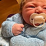 baby, newborn, pacifier, blue_sweater, knitted_clothing, infant, close_up, fist, soft_texture, indoor, cute, child, person, skin, hair, warm_clothing, portrait, hand, baby_clothes, sleepy