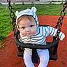baby, blue_eyes, casual_wear, chain, child, cute, face, grass, hoodie, infant, outdoor, park, person, playground, red_surface, seat, smiling, striped_clothing, swing, young_child