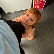 Kody joined the competition — help win amazing prizes! toddler, child, barefoot, curious, kitchen, floor, snack_box, looking_up, clothing, person, indoor, young_child, hair, face, hand, diaper, flooring, orange_bag, light, expression
