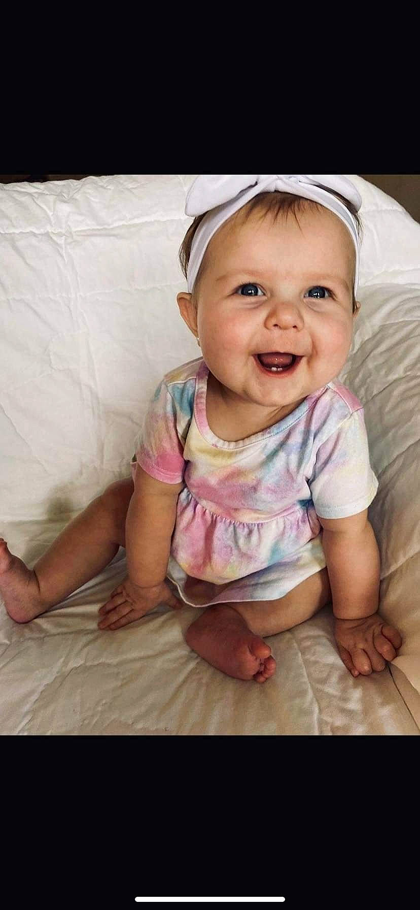 Emberlyn joined the competition — help win amazing prizes! baby, baby_laughing, baby_toddler_clothing, cheek, child, comfort, flooring, fun, happy, joy, linens, pattern, person, pink, portrait_photography, sitting, skin, sleeve, smile, t_shirt
