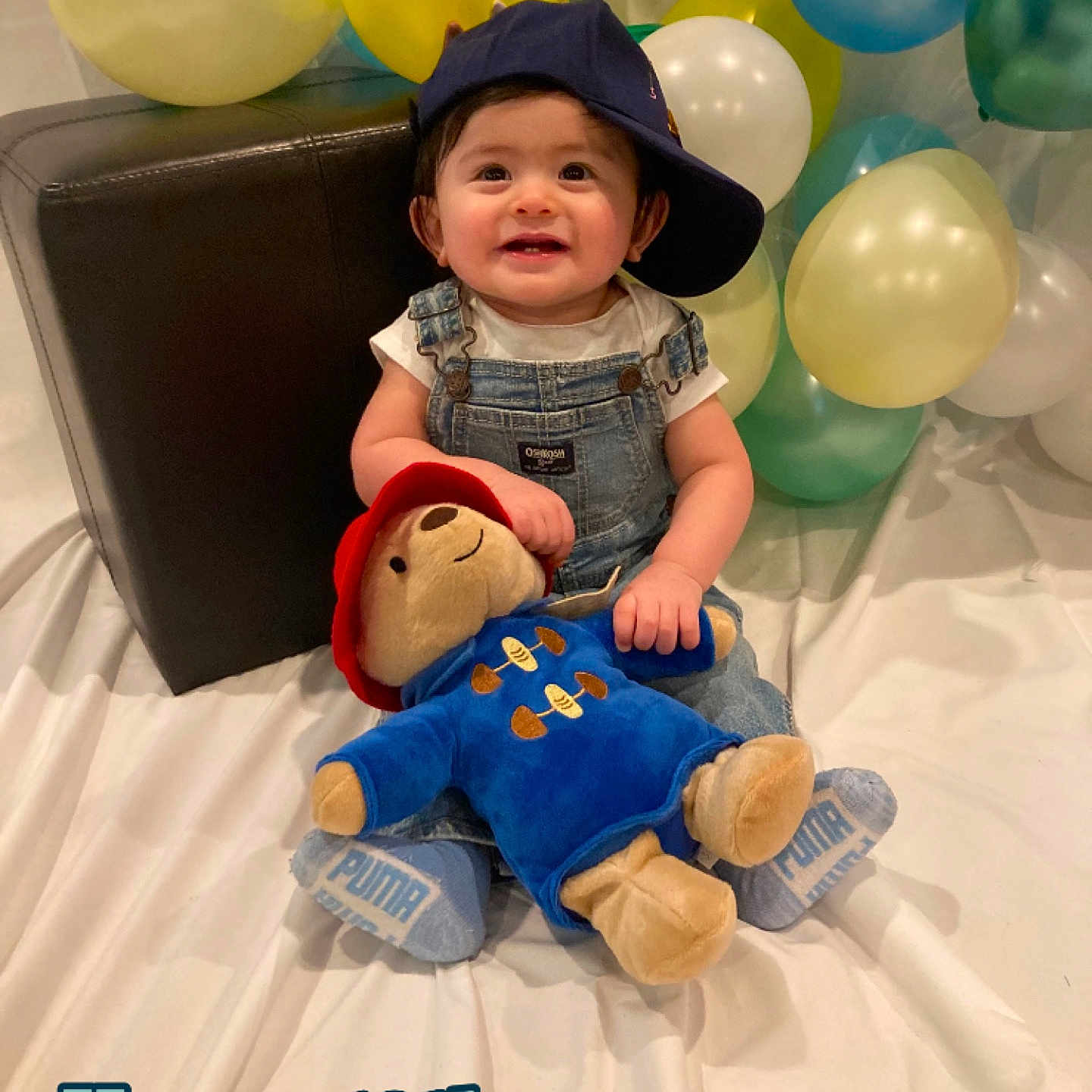 Ryan is registered to the contest to win money with this photo: baby, balloon, baseballcap, cap, clothing, costume, face, footwear, hat, head, jeans, pants, people, person, photography, portrait, purple, shoe, sitting, toy