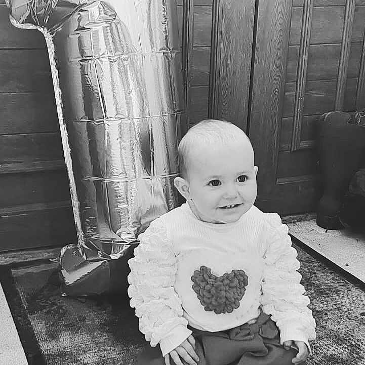Mya participe au concours pour gagner de l'argent avec cette photo : baby, ball, brasssection, clothing, face, football, happy, head, horn, pants, people, person, photography, portrait, sitting, sleeve, smile, soccer, soccerball, sport