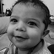Léo participe au concours pour gagner de l'argent avec cette photo : baby, black_and_white, child, close_up, clothing, curly_hair, cute, expression, eyes, face, happy, indoor, infant, necklace, person, portrait, sitting, smiling, toddler, young_child