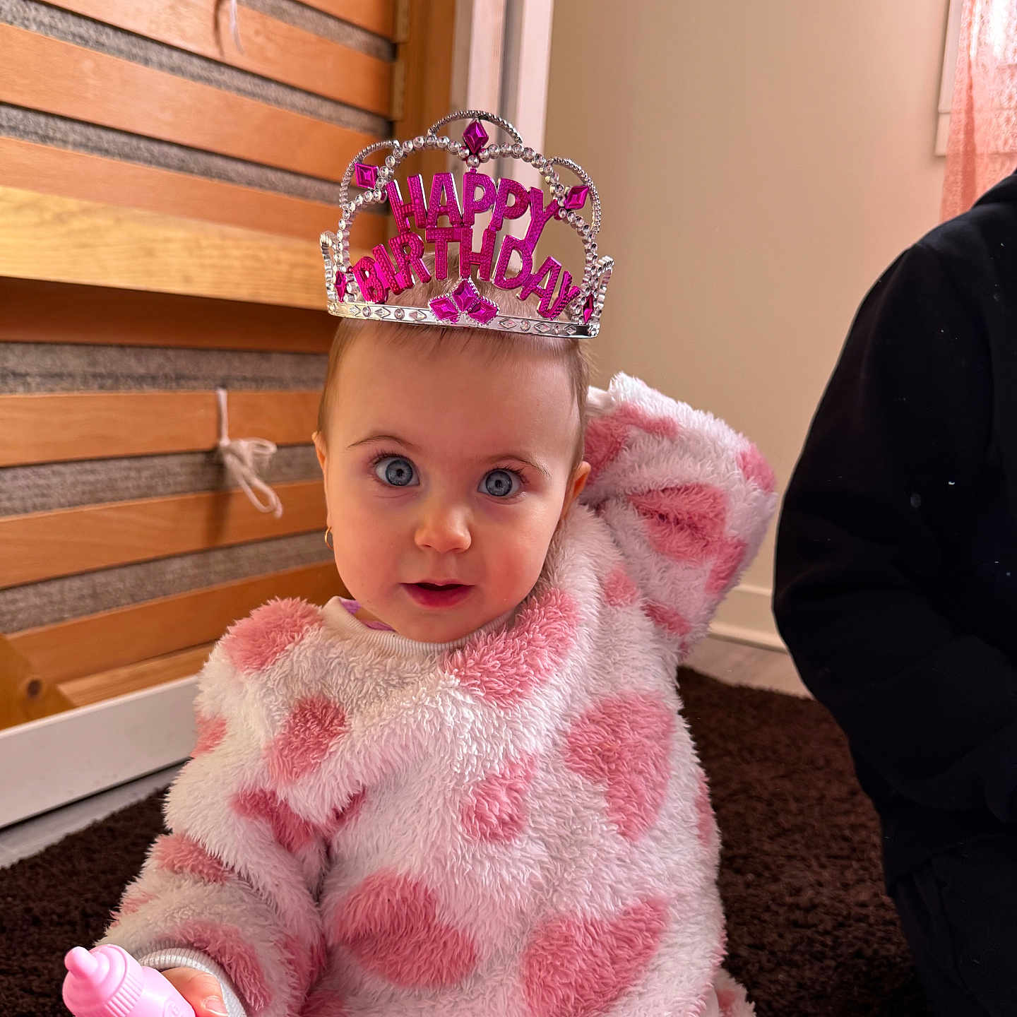 Gabriela participe au concours pour gagner de l'argent avec cette photo : toddler, child, birthday, tiara, pink, fuzzy_clothing, toy, indoor, carpet, wooden_wall, person, cute, portrait, blue_eyes, celebration, baby, happy, sitting, hand, cozy