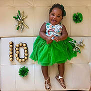 Isadora joined the competition — help win amazing prizes! baby, toddler, child, smiling, green_skirt, tulle_skirt, sandals, couch, celebration, chocolates, candies, number_ten, festive_props, hair_bow, portrait, happy, laying_down, party_pom_pom, skin_tone, photography