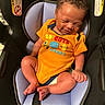 Kaisen is registered to the contest to win money with this photo: baby, infant, car_seat, orange_onesie, happy, smiling, child, cute, seated, indoors, curly_hair, skin, face, clothing, child_seat, safety, infant_clothing, small_child, person, baby_smile