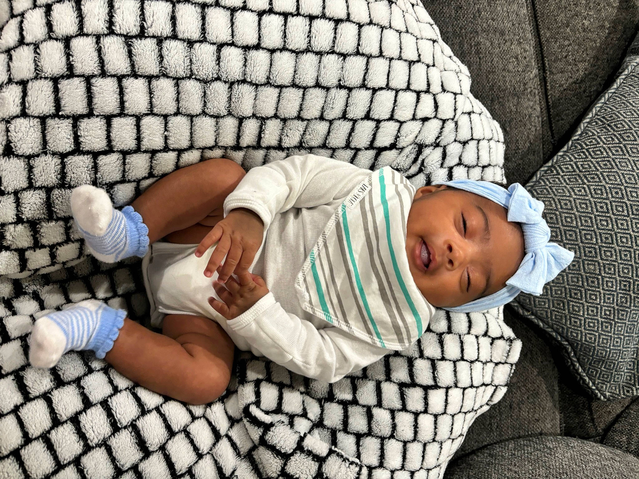Zariyah is registered to the contest to win money with this photo: baby, baby_products, baby_toddler_clothing, child, comfort, foot, grass, headwear, human_leg, knee, leisure, linens, mammal, pattern, person, product, shorts, sitting, sock, t_shirt