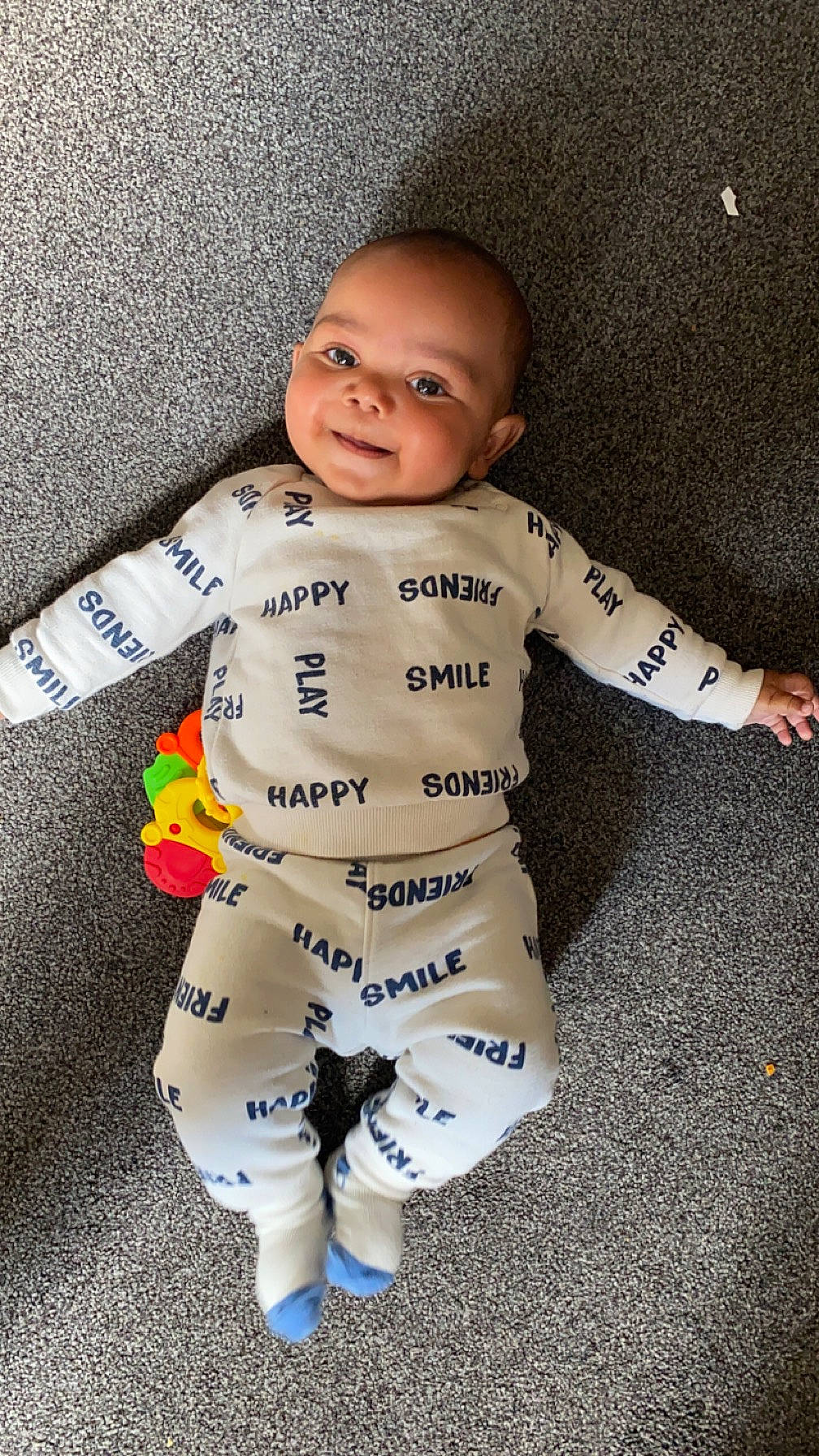 Blake is registered to the contest to win money with this photo: arm, baby, baby_toddler_clothing, carmine, fashion_design, flooring, fun, fur, gesture, happy, human_body, pattern, person, personal_protective_equipment, sleeve, smile, sportswear, suit, thumb, toddler