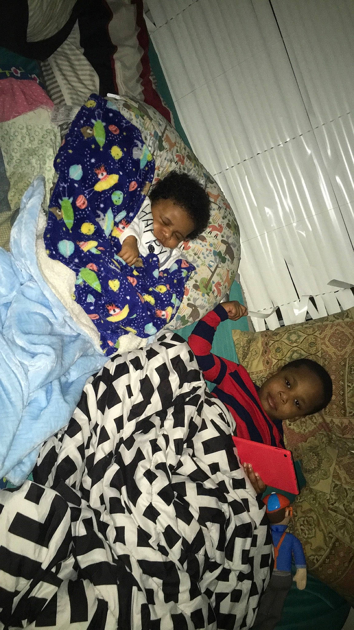 Carter is registered to the contest to win money with this photo: bedding, child, comfort, event, fashion_design, fun, happy, leisure, linens, luggage_and_bags, mammal, pattern, person, play, room, sitting, tints_and_shades, toddler, tradition, vacation