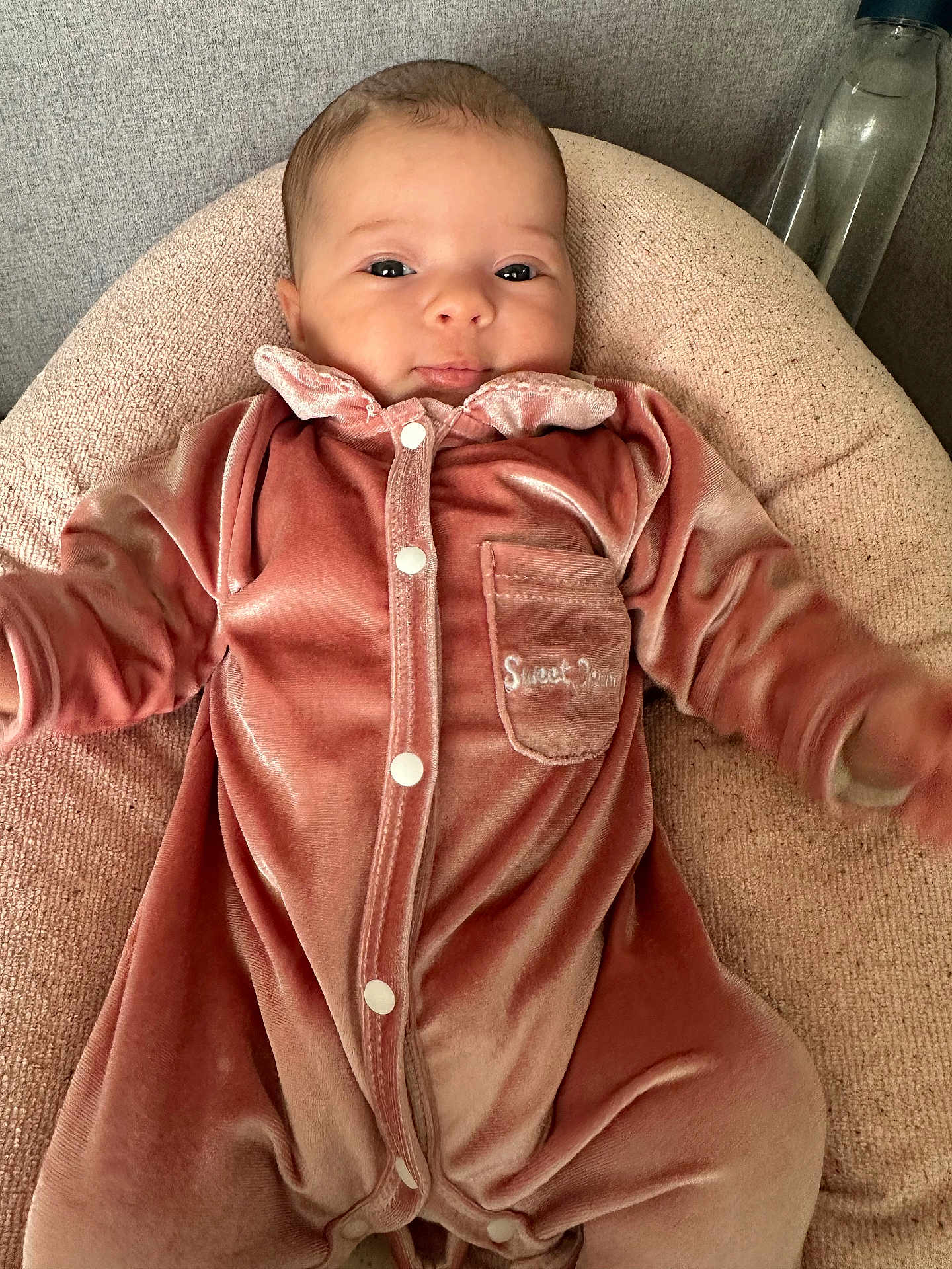 Annalya a rejoint le concours — aidez-le/la à gagner de superbes lots ! baby, infant, onesie, pink_clothing, velvet, pocket, cushion, face, eyes, bottle, soft_texture, neutral_background, cute, child, portrait, sleepwear, indoor, resting, comfortable, small