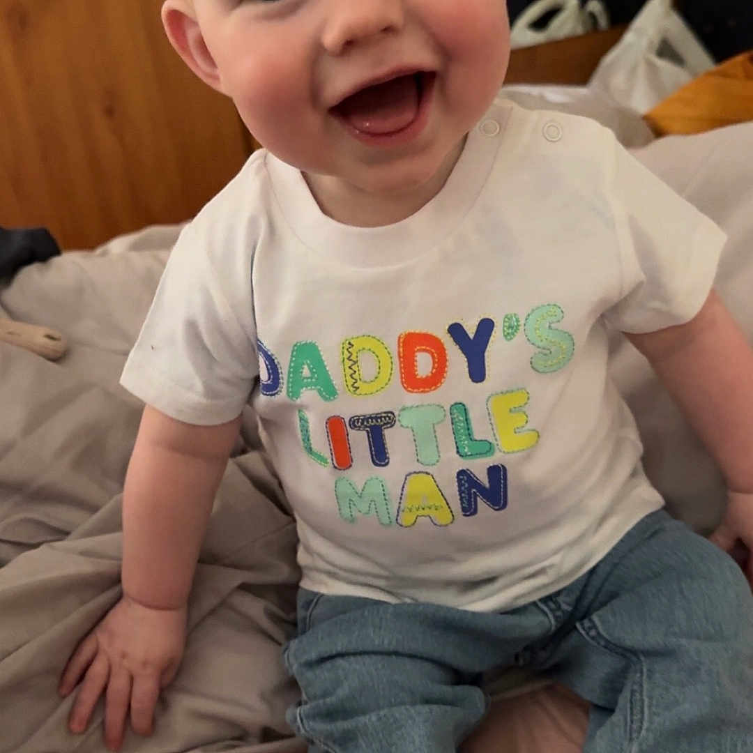 Cody joined the competition — help win amazing prizes! baby, babylaughing, bed, clothing, couch, face, furniture, happy, head, hosiery, jeans, laughing, pants, person, photography, portrait, sitting, smile, sock, t_shirt
