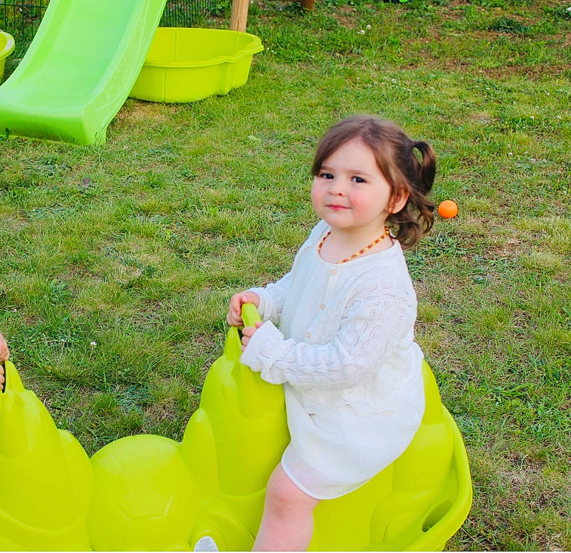Théa a rejoint le concours — aidez-le/la à gagner de superbes lots ! baby_toddler_clothing, child, chute, event, fun, garden, grass, green, happy, joy, leisure, people_in_nature, person, photograph, plant, play, playground, recreation, sitting, smile