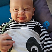 Helios participe au concours pour gagner de l'argent avec cette photo : baby, blue_background, child, clothing, cushion, cute, face, hand, happy, head, indoor, infant, panda_design, person, portrait, purple_background, smiling, striped_clothing, tongue_out, young