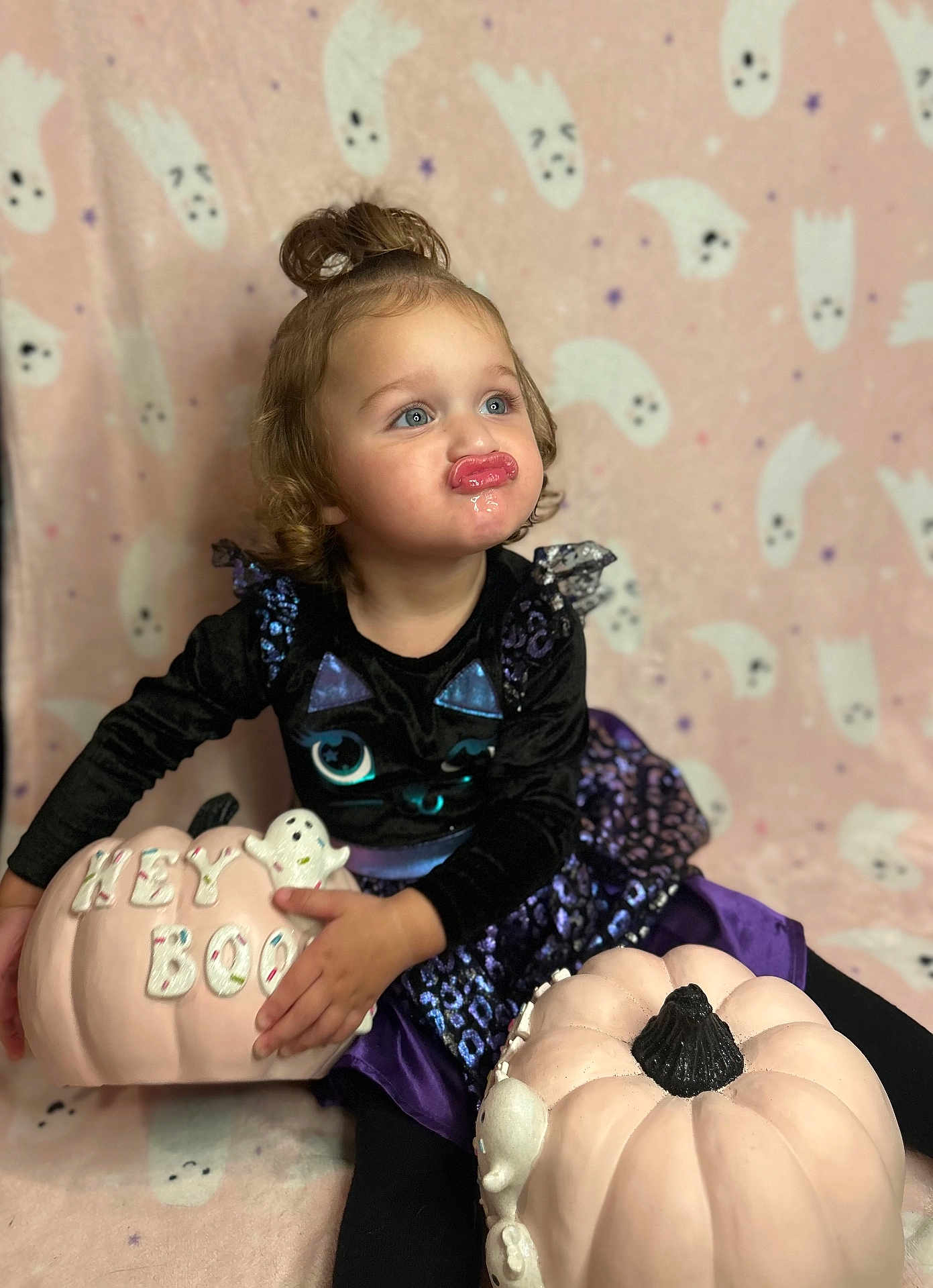 Ocean joined the competition — help win amazing prizes! toddler, child, girl, pumpkin, halloween, costume, black_dress, purple_skirt, ghost_pattern, background, blue_eyes, curly_hair, top_bun, pouting, sitting, holiday, decor, cute, playful, indoor