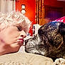 Bella joined the competition — help win amazing prizes! woman, dog, face, closeup, puckered_lips, pet, indoor, couch, curly_hair, earrings, brindle_dog, nose_to_nose, expression, wooden_furniture, pillow, blanket, curtain, portrait, affection, interaction