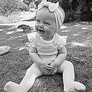Nova-Rae joined the competition — help win amazing prizes! baby, child, smiling, headband, bow, grass, outdoor, nature, duck, knitted_clothing, tights, happy, sitting, sunlight, daylight, park, person, cute, portrait, young_child