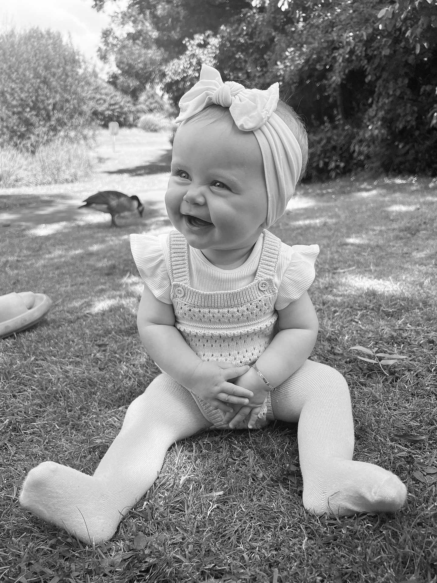 Nova-Rae joined the competition — help win amazing prizes! baby, child, smiling, headband, bow, grass, outdoor, nature, duck, knitted_clothing, tights, happy, sitting, sunlight, daylight, park, person, cute, portrait, young_child