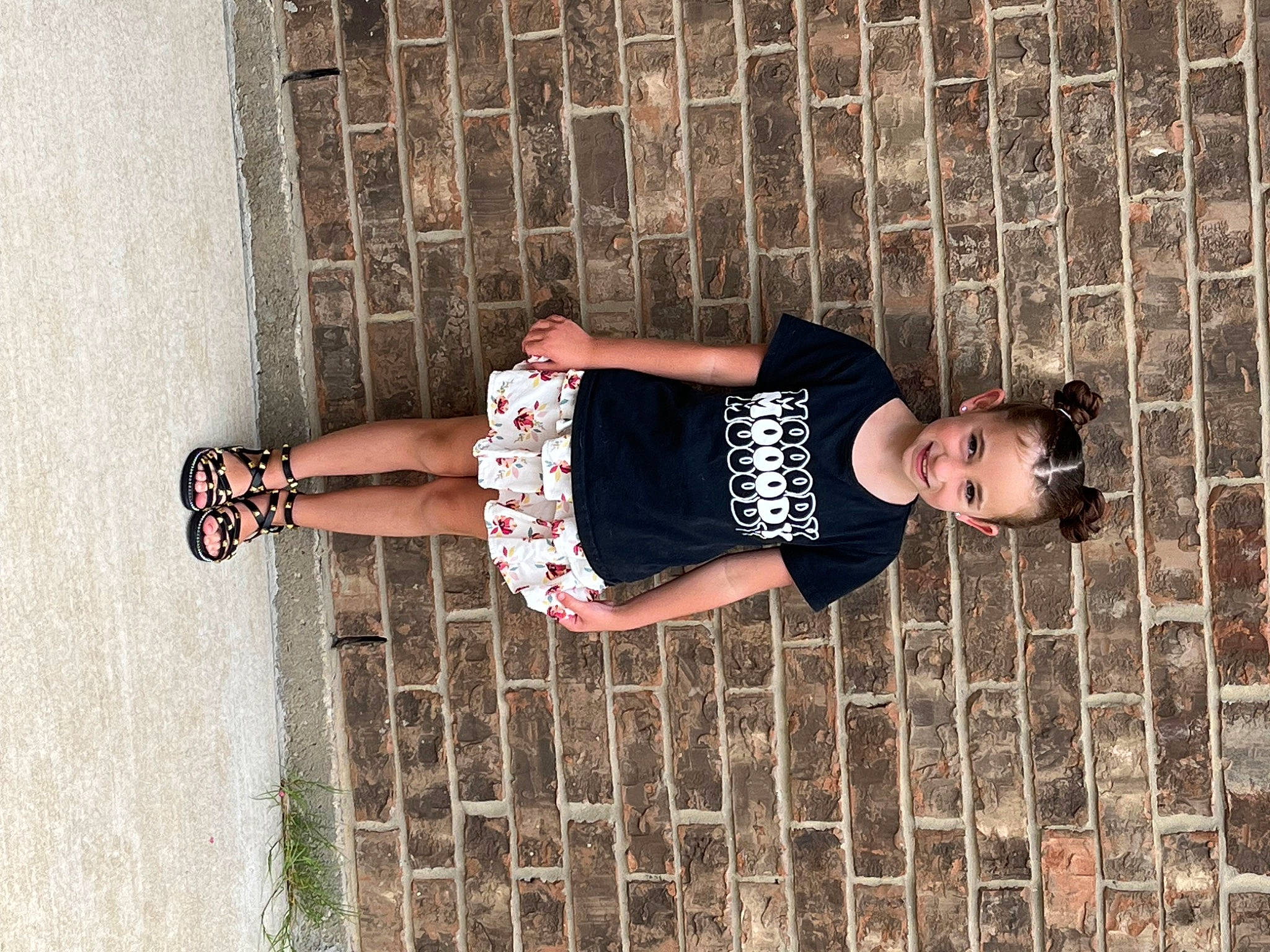 Zoey is registered to the contest to win money with this photo: arm, child, composite_material, design, elbow, eyewear, foot, footwear, human_leg, joy, knee, leg, pattern, person, shadow, sleeve, t_shirt, textile, thigh, waist