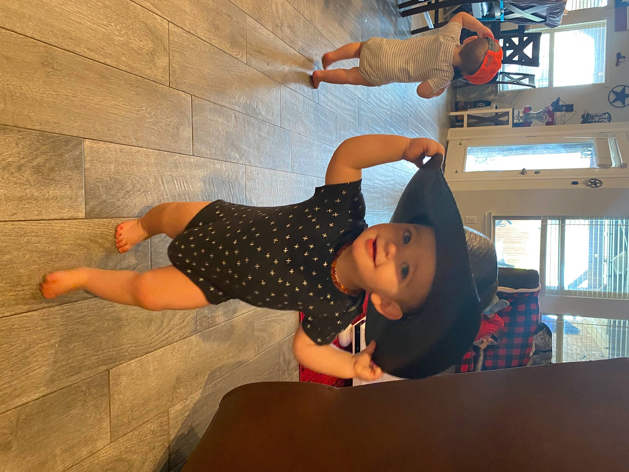 Jaxon is registered to the contest to win money with this photo: child, comfort, elbow, flooring, fun, hat, headwear, human_leg, joy, knee, leisure, person, room, t_shirt, thigh, toddler, vacation, wood