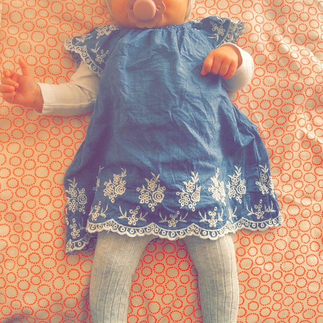 Celya participe au concours pour gagner de l'argent avec cette photo : baby, infant, pacifier, headband, blue_dress, white_tights, lying_down, patterned_blanket, indoors, cute, child, small_hands, sleepy, soft_lighting, portrait, adorable, baby_fashion, resting, calm, cozy