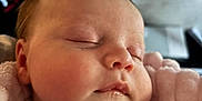 Lottie is registered to the contest to win money with this photo: baby, blanket, cheeks, closeup, clothing, face, head, indoor, infant, mouth, nose, peaceful, person, pink, portrait, rest, skin, sleeping, soft, young
