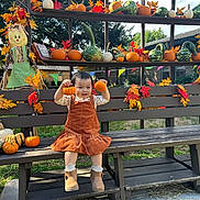 Lisa is registered to the contest to win money with this photo: child, toddler, smiling, outdoor, autumn, fall, pumpkin, gourds, scarecrow, leaves, bench, dress, boots, portrait, festival, decoration, garden, sitting, seasonal, colorful