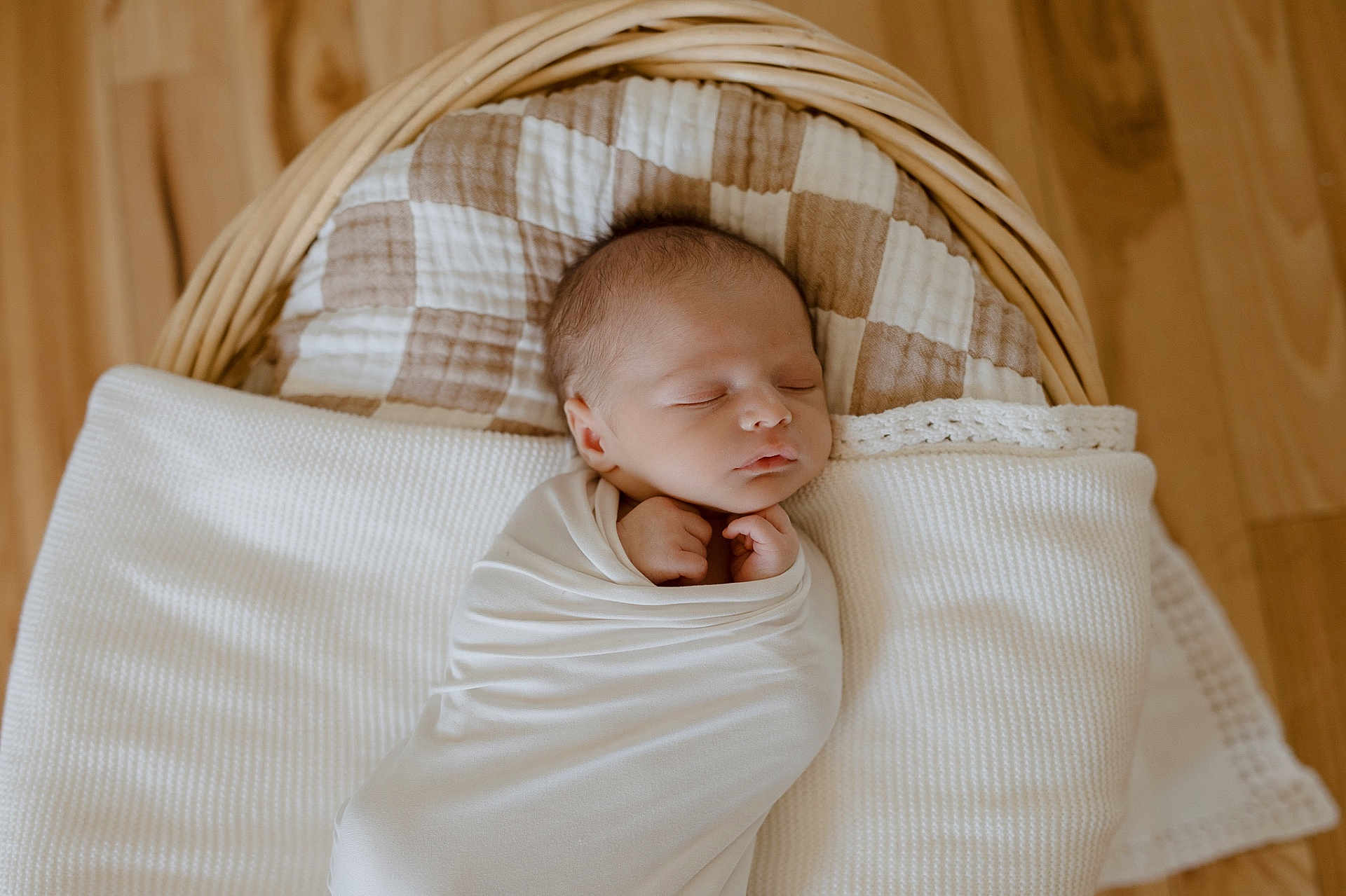Isaac is registered to the contest to win money with this photo: newborn, baby, sleeping, swaddled, blanket, basket, cushion, wooden_floor, infant, peaceful, cozy, resting, indoors, portrait, head, face, child, soft_lighting, wrapped, quiet