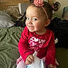 Roselina joined the competition — help win amazing prizes! toddler, child, smile, red_shirt, flower_headband, bed, blankets, pillow, tissue, indoor, cute, happy, person, hair_buns, pink, playful, young_child, sitting, face, portrait