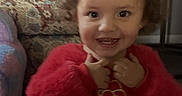 Roselina joined the competition — help win amazing prizes! toddler, child, smiling, red_clothing, curly_hair, indoor, armchair, pillow, furniture, phone_screen, lock_screen, notification, time_display, date_display, portrait, person, happy, couch, home, cute