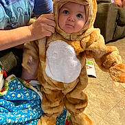 Jameson joined the competition — help win amazing prizes! baby, blanket, bonnet, child, clothing, costume, face, female, girl, happy, hat, head, hood, person, photobombing, photography, portrait, sitting, smile, toy