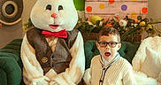 Ashton joined the competition — help win amazing prizes! child, boy, glasses, easter_bunny, costume, couch, green_couch, easter_eggs, wooden_eggs, holiday, indoor, decorations, clock, vintage_clock, vest, bow_tie, white_fur, smiling, festive, casual_clothing