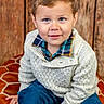 Ashton joined the competition — help win amazing prizes! child, boy, smiling, blue_eyes, sweater, plaid_shirt, blue_pants, cushion, orange, wooden_background, portrait, casual_clothing, seated, indoor, cute, happy, young, face, fashion, knitwear