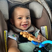 Thiago joined the competition — help win amazing prizes! baby, car_seat, toy, smile, happy, child, infant, seatbelt, clothing, indoor, person, cute, face, hand, photography, closeup, safety, car_interior, play, joy