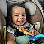 baby, car_seat, toy, smile, happy, child, infant, seatbelt, clothing, indoor, person, cute, face, hand, photography, closeup, safety, car_interior, play, joy