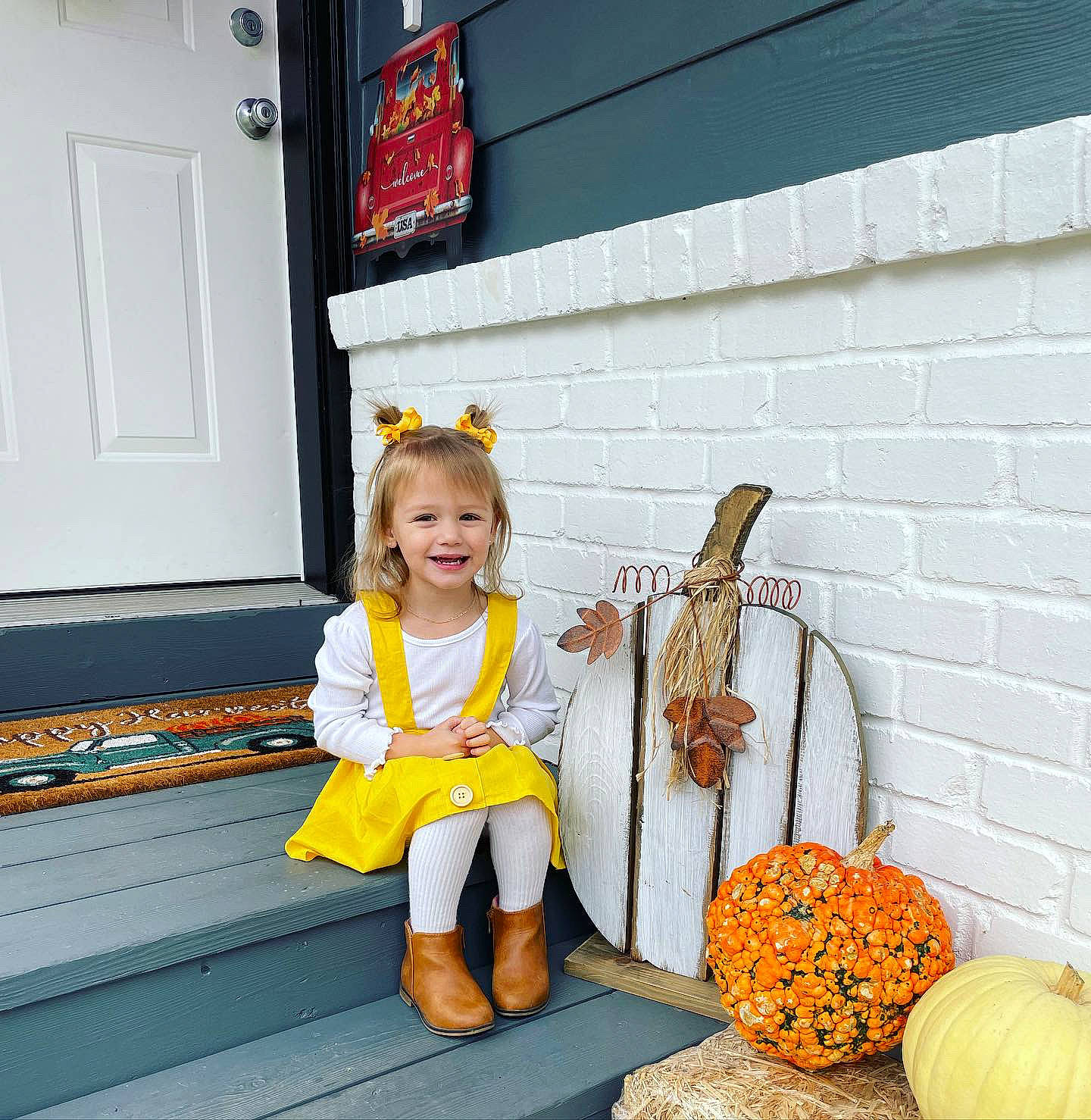 Sophia is registered to the contest to win money with this photo: calabaza, child, cucurbita, door, flower, fruit, fun, gourd, hat, headgear, joy, natural_foods, orange, person, plant, pumpkin, room, smile, television, toddler