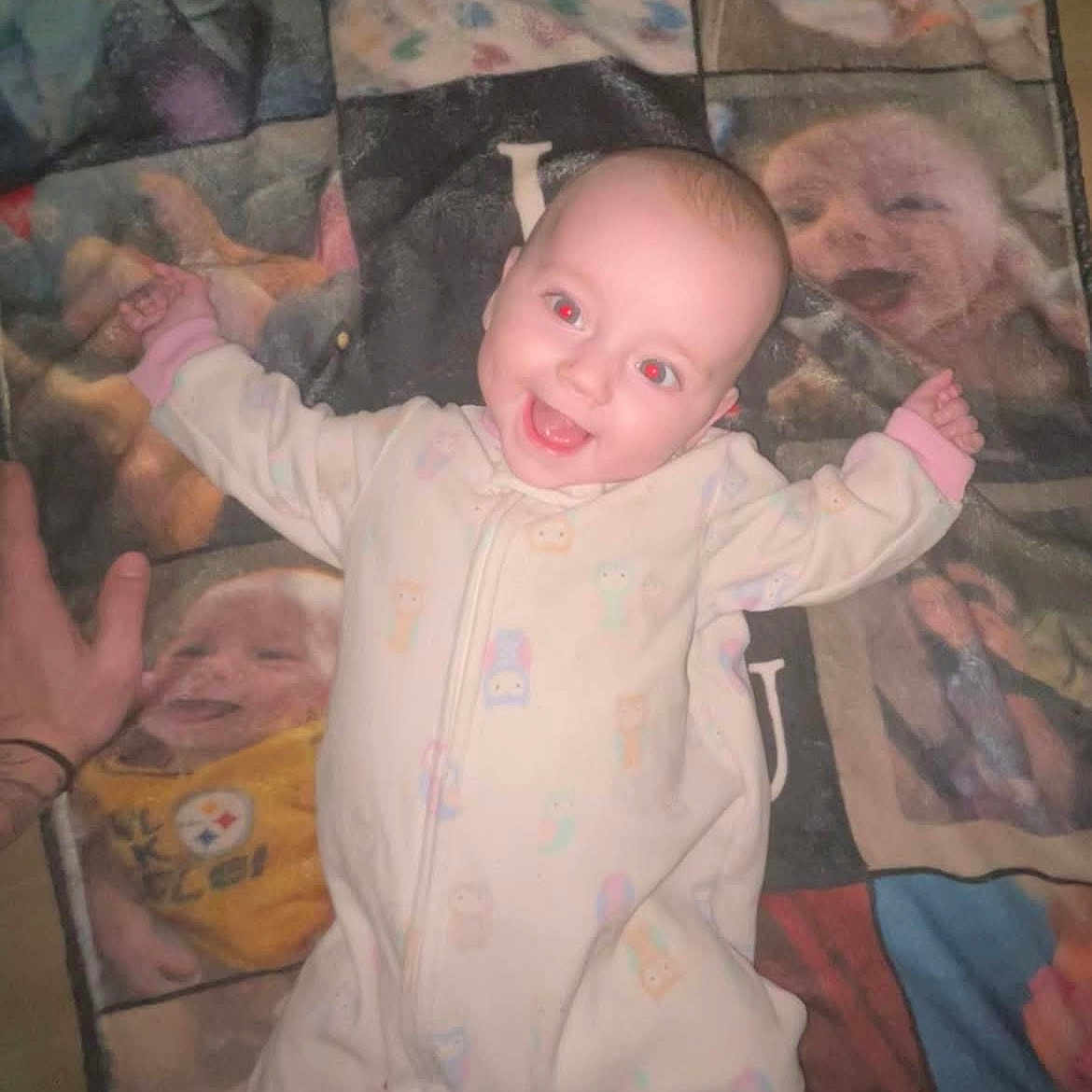 Everleigh Dawn is registered to the contest to win money with this photo: baby, blanket, child, cozy, cute, face, hand, happy, indoor, infant, lying_down, onesie, pastel_colors, pattern, portrait, quilt, red_eye, sleepwear, smiling, soft_fabric