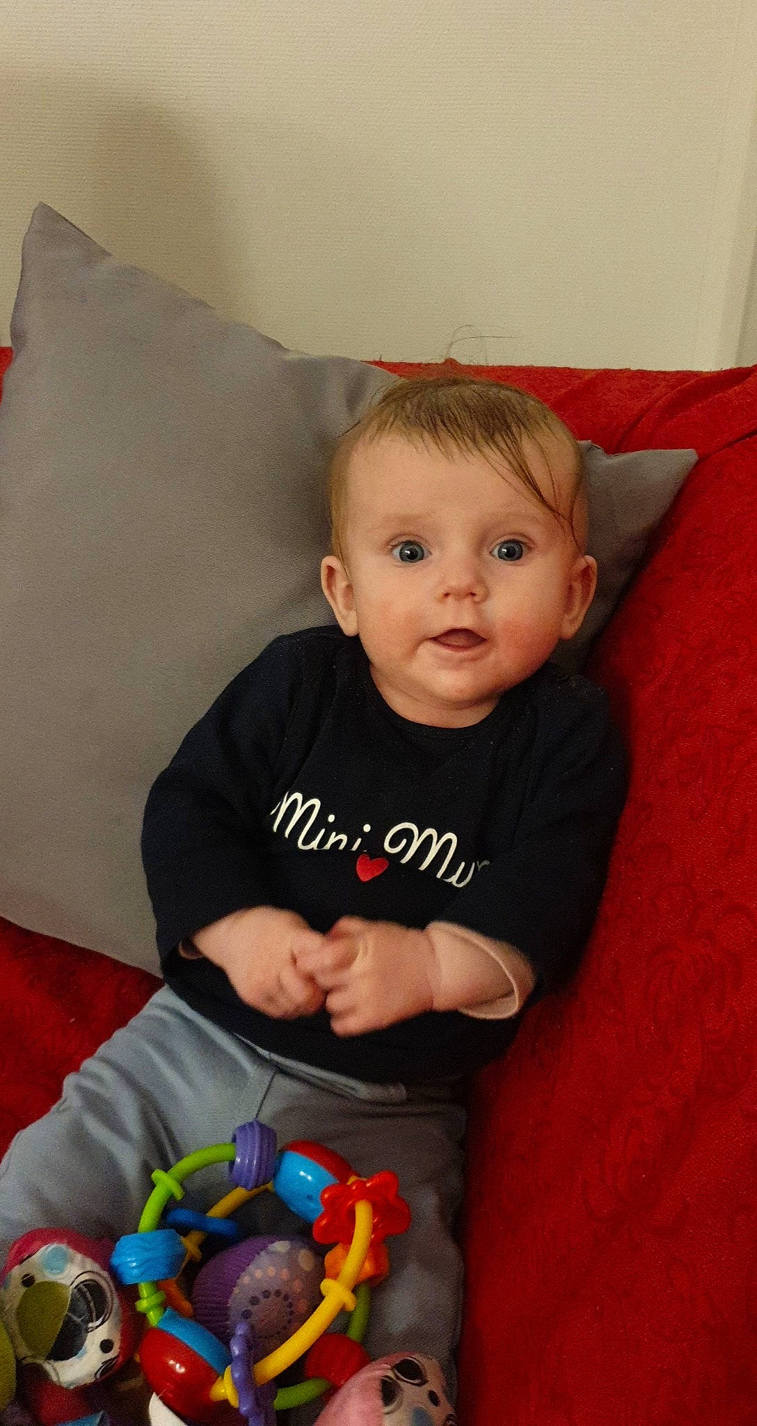 Lola a rejoint le concours — aidez-le/la à gagner de superbes lots ! baby, baby_playing_with_toys, baby_toddler_clothing, baby_toys, blond, child, comfort, couch, cushion, ear, face, home_accessories, linens, living_room, nose, person, pillow, play, sock, throw_pillow