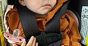Emberley joined the competition — help win amazing prizes! baby, car_seat, child, closed_eyes, cozy, earring, hands, headband, indoor, infant, orange_clothing, pacifier, peaceful, portrait, safety_harness, seated, sleeping, text_label, travel, vehicle