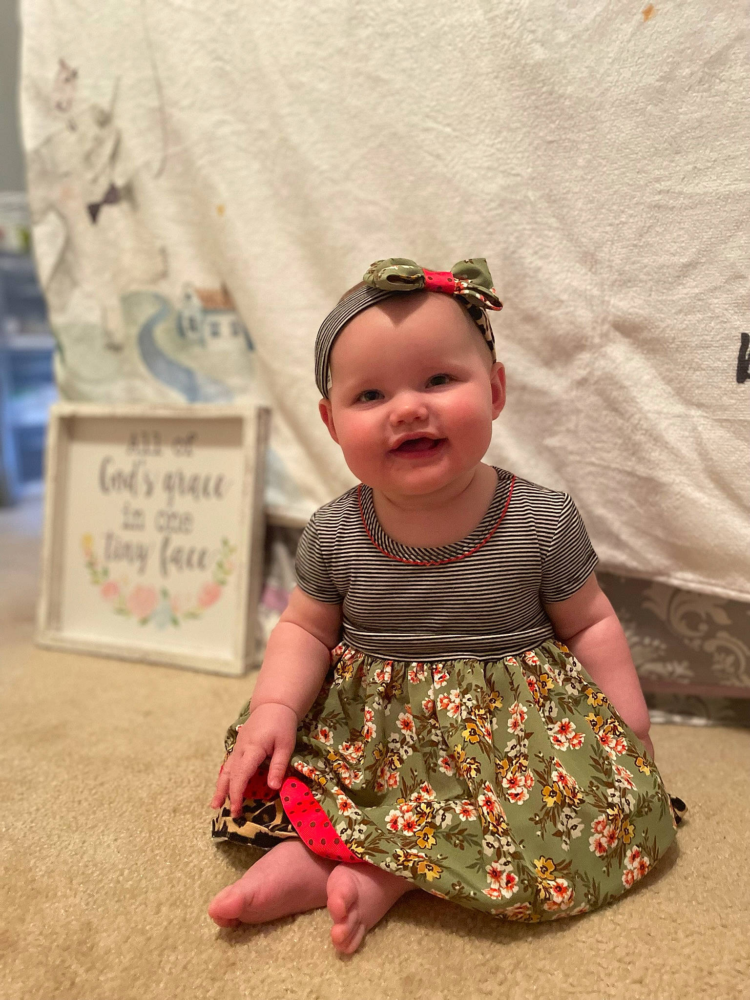 Gracy is registered to the contest to win money with this photo: baby_toddler_clothing, child, costume, fashion_design, flooring, foot, fun, happy, hat, headgear, headwear, joy, magenta, pattern, person, pink, sitting, skin, sleeve, smile