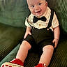 baby, infant, smiling, bow_tie, suspenders, red_shoes, polka_dot, couch, green_couch, happy, cute, child, indoors, portrait, sitting, clothing, footwear, person, fashion, baby_shoes