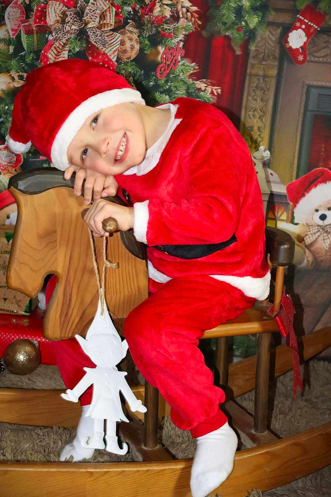 Coppin participe au concours pour gagner de l'argent avec cette photo : child, smiling, santa_hat, christmas_costume, rocking_horse, holiday_decor, stocking, teddy_bear, christmas_tree, gift_wrap, festive, indoor, happy, toy, wooden, red_clothing, white_socks, decoration, holiday_season, portrait