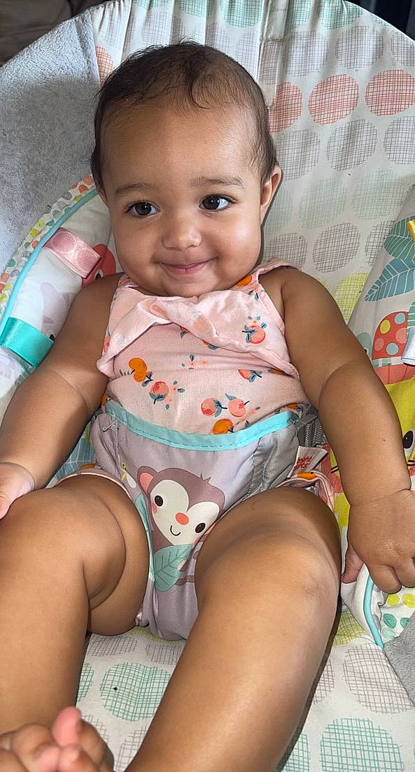 Iyla is registered to the contest to win money with this photo: baby_toddler_clothing, cheek, chin, eye, face, facial_expression, hairstyle, happy, head, human_body, iris, joy, leg, mouth, neck, nose, organ, person, pink, skin