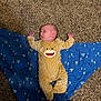 baby, infant, onesie, yellow_clothing, blanket, blue_blanket, carpet, floor, lying_down, sleepy, face, person, child, indoor, pajamas, pattern, soft_texture, cute, resting, baby_clothing