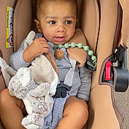 Melvyn participe au concours pour gagner de l'argent avec cette photo : baby, baby_boy, car_seat, child, comfort, cute, face, foot, hand, head, indoor, infant, person, plush_toy, seatbelt, sitting, skin, small_child, striped_clothing, toy
