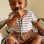 Melvyn a rejoint le concours — aidez-le/la à gagner de superbes lots ! baby, beads, blanket, brown_skin, casual_clothing, child, comfort, cute, happy, home, indoor, pacifier, playful, portrait, seated, short_hair, smiling, striped_clothing, striped_socks, toddler