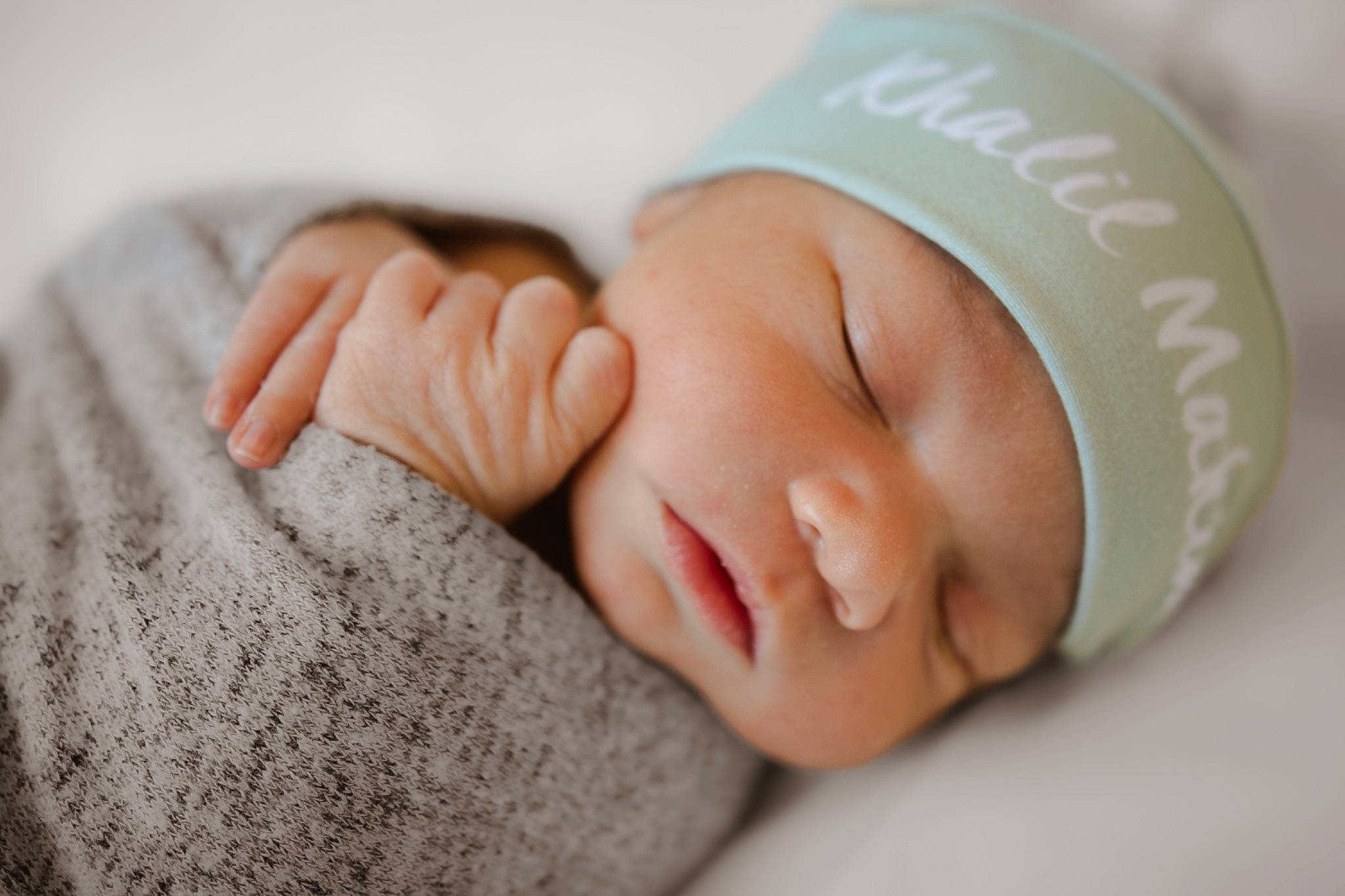 Khalil is registered to the contest to win money with this photo: arm, baby, baby_sleeping, baby_toddler_clothing, cap, child, comfort, facial_expression, fashion_accessory, finger, gesture, hand, happy, headgear, nail, person, portrait_photography, skin, sleeve, thumb