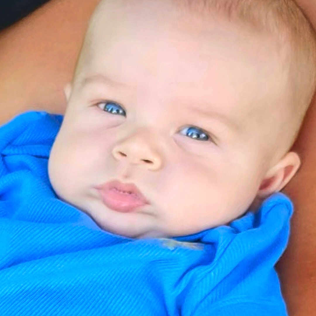 Daxton is registered to the contest to win money with this photo: baby, biting, blonde, face, hair, happy, head, newborn, person, photography, portrait, smile