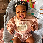 Skylar joined the competition — help win amazing prizes! baby, infant, smiling, sitting, bouncer, pink_clothing, hair_clip, bow, cute, laughing, face, eyes, hands, legs, sunlight, rainbow, monkey_graphic, patterned_shorts, home_interior, soft_toy